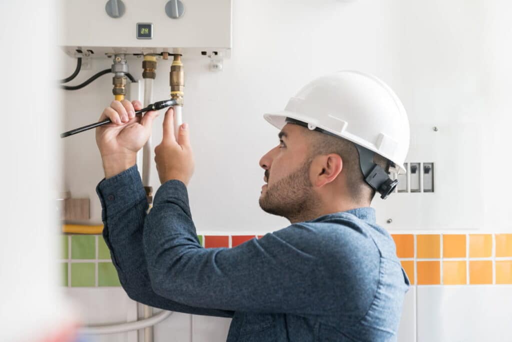 technician fixing a hot water heater system