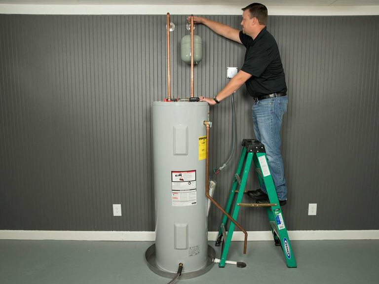 a guy installing a hot water heater system